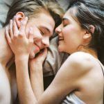 A joyful and intimate moment of a young couple embracing and smiling together.