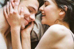 A joyful and intimate moment of a young couple embracing and smiling together.